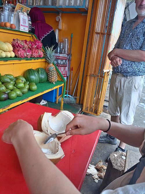Sampling freah coconut given to us buy the owner.  at Happy Fruits Smoothie in Semporna