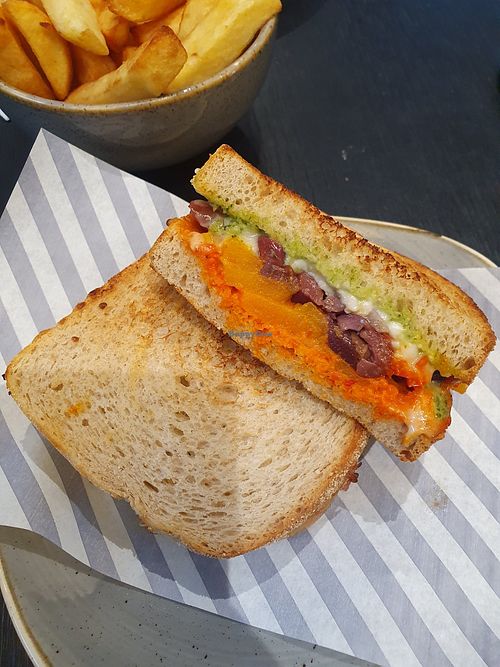 Veggie toastie: seasoned butternut squash, red onion, peppers, vegan feta cheese & black olives with red pepper tapenade & a herby vegan dressing on sourdough bread. With chips at Marks & Spencer in Wilmslow