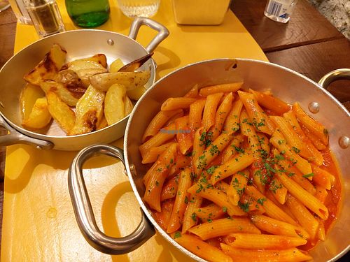 Penne arrabbiata and baked potatoes at La Pasta Taverna in Como
