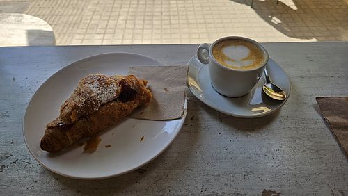Vegan croissant with strawberry jam and coffee with oat milk at Crois Spazio Bar in Barcelona