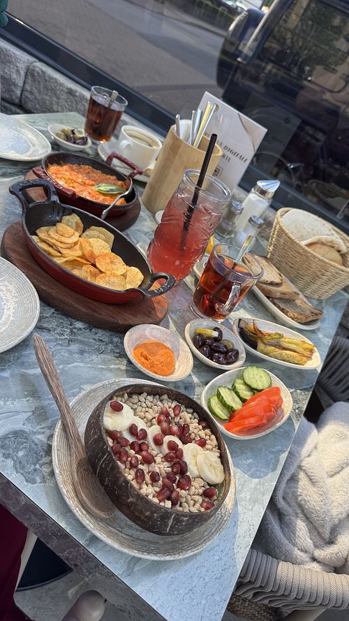 Veganes Frühstück mit glutenfreie veganen Brot, Bowl, Paprikadip, „Chips“, gegrilltes Gemüse, Obst, … Auf der linken Seite ist ein vegetarisches Gericht (Menemen)  at Café de Mola in Bielefeld