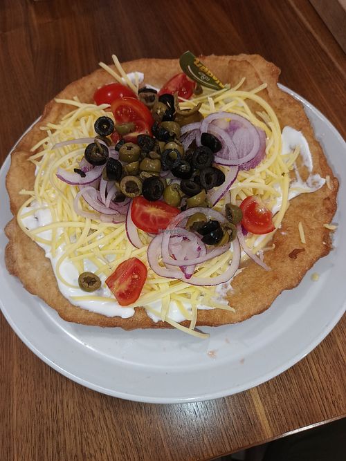 Lángos with vegan sour-cream,  vegan cheese, red onion,  olives (black and green), tomato at Retro Lángos Budapest Vécsey 3 in Budapest