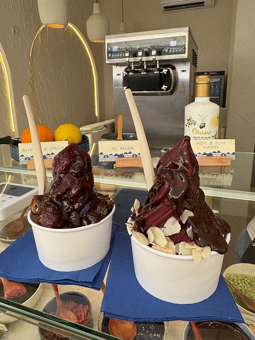 Açai sorbet medium with: 
- dates and dark chocolate sauce (left)
- shaved almonds and dark chocolate sauce (right) at Kefi Greek Frozen Yogurt in Valencia