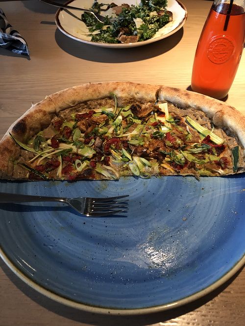 Vegan pizza with artichoke, charred broccolini, summer squash, pickled jalapeño, basil cashew drizzle, garlic oil, and sunflower seeds  at Marzano in Nelson