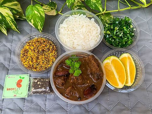vegan feijoada: includes plant-based meat chunks, steak and sausage, rice, seasoned crunchy soy farofa, sautéed collard greens, orange slices, and rapadura  at Broto Veg: Feijoada Vegana in Parnamirim