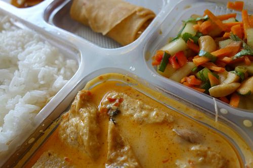 A Veggiesaurus Food Box, all vegan -  jasmine rice, spicy red curry, spring rolls, cassava chips and Thai salad with cashews. at Veggiesaurus in The Hague