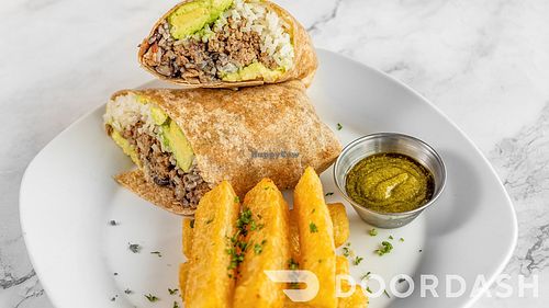 CUBAN WRAP/Black beans, rice, picadillo (impossible beef) avocado, plantains, wheat wrap. Served with yuca fries. (Gluten-Free Wrap Available) at Vegan Tierra  in North Miami
