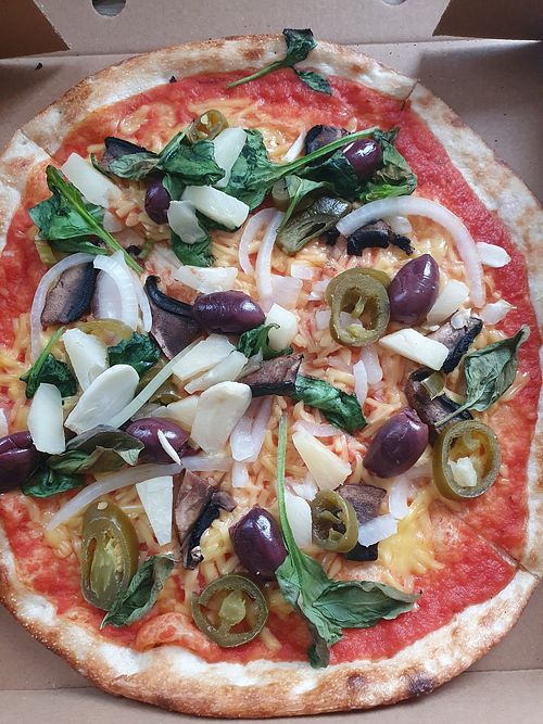 Vegan cheese with onion, roasted garlic, portobello mushroom, pineapple, Jalapenos, kalamata olives, spinach, and basil at 900 Degrees in England
