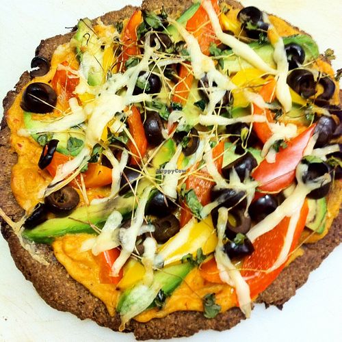 Macho Nacho Wheat-free Personal Pizza. Iss' Magic Mixes crust topped with red pepper hummus, fresh pico de gallo, fresh avocado, bell peppers & black olives. only at the Oatmeal Café at Iss' Magic Mixes Oatmeal Cafe in Mesa
