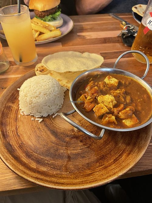 tofu tikka, rice and naan with a popadom and vegan burger in the background   at The Golden Fleece in Porthmadog