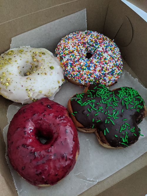 Rose pistachio, vanilla sprinkle, blueberry and a holiday feature filled donut at bloomer's in Toronto