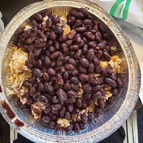 I checked with the kitchen. Rice is made with hot water and spices. No broth is used. The black beans are vegan. at Main Street Taco Express in Hale