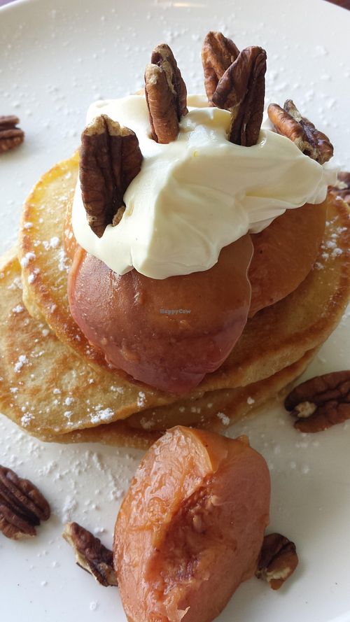Vegetarian pancakes, short stack, with peach and cream. Vegan option is available.  at True North in Coburg