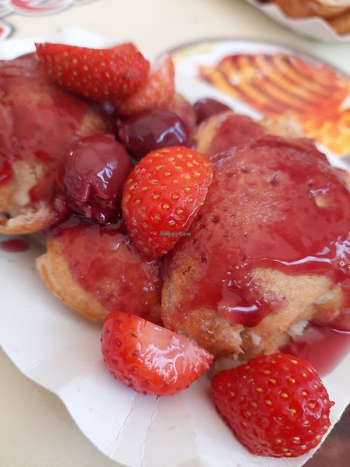 Vegan poffertjes with fresh strawberries and hot cherries in sauce. at JoJo Poffertjes in Gelderland