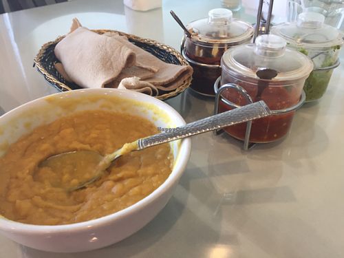 Yellow lentils, basket of spongy injera, and sauces at Rahel's Vegan Cuisine in Los Angeles