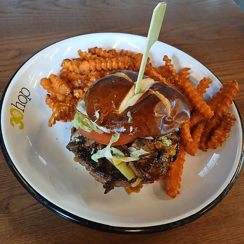 Vegan Burger: impossible patty, vegan cheese, vegan mayo, soy garlic glaze, & cremini mushrooms on a pretzel bun w/ (+$1) sweet potato fries at 30hop in Omaha