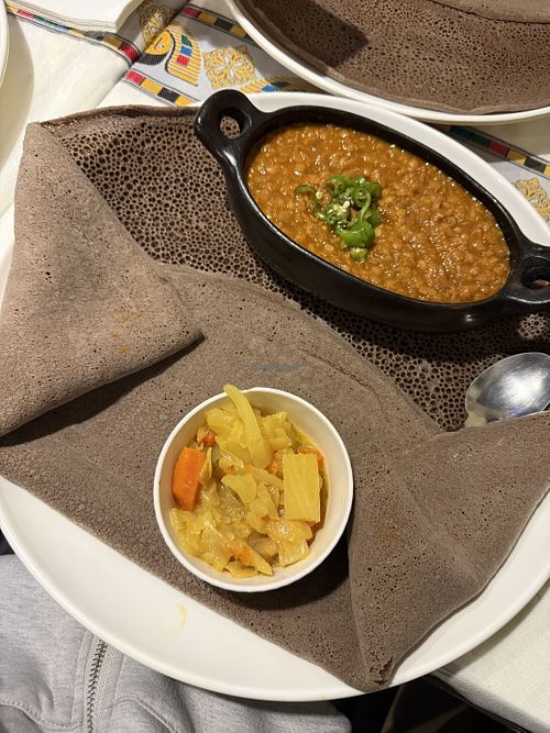 Lentil stew with injera and veggies on the side   at Amen Habesha Restaurant in Nottingham