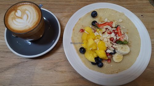 Oat milk latte and pancake with fresh fruit and extra nuts - lovely light breakfast at Kin Cafe Vegetarian in London