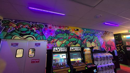 Interior bar wall art at LeaderBoard Arcade Bar & Pizzeria Jax in Jacksonville