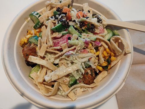 Custom bowl with falafel, lentils, brown rice, corn, cucumbers, sumac slaw, roasted vegetables, pita strips, pickled onions, eggplant dip, original hummus, tahini caesar dressing. at CAVA in Naples