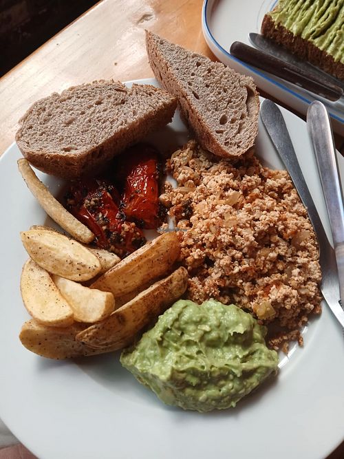 Tofu, toast, stewed tomatoes, guacamole, and potatoes.  Such a good breakfast. at Mandarina in Quetzaltenango