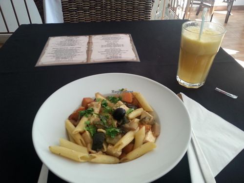 Vegan main course of Penne with vegetables with tofu,  and apple and orange juice at Pedacos de Glamour in Cascais