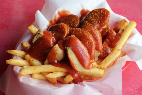 Fries topped with sliced vegan sausage and curry sauce  at Beelzebab in Brighton