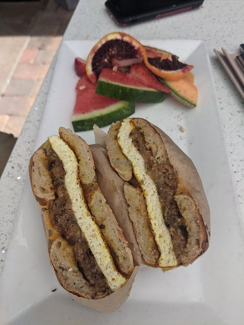 Bagel sandwich with tofu, sausage, and american cheese. Comes with fruit. 😋 at JOi Café in Westlake Village