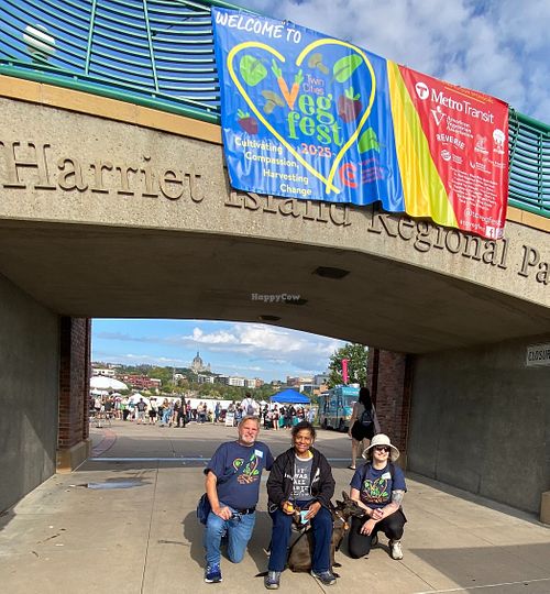Volunteers greeters at Twin Cities Veg Fest 2025 -- busy festival in the background! at Compassionate Action for Animals in Minneapolis