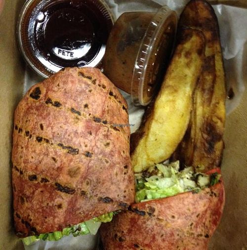 Jerk Tofu Wrap with potatoe wedges, BBQ dipping sauce, & extra jerk sauce at Karyn's Cooked in Chicago