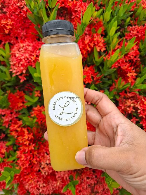 Refrescante bebida natural de naranja y raspadura, elaborada con ingredientes locales siguiendo una receta familiar. at Lorettas Cuisine in Panama City