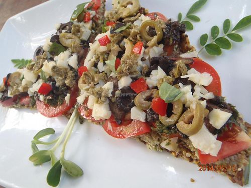 Living pizza with sprouted seed crust, portobellos capers, pesto, nut cheese, hearts of palm,crunchy creamy and flavorful.  at Raw Love - Ahau Tulum Beach in Tulum