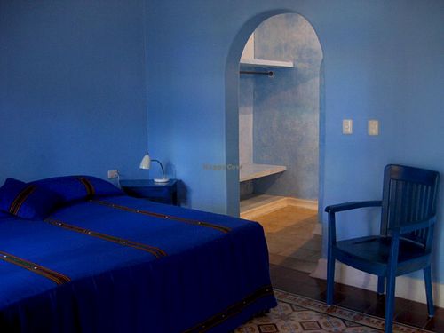 This spacious simply decorated air-conditioned room has a king-sized bed, private bathroom with shower, a ceiling fan, a separate dressing area and an uncluttered Mexican decor. at Hotel MedioMundo in Merida