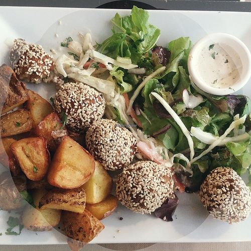 Roasted potatoes, sesame and rice balls, salad and sauce at Mezzaluna in Saint-laurent-blangy