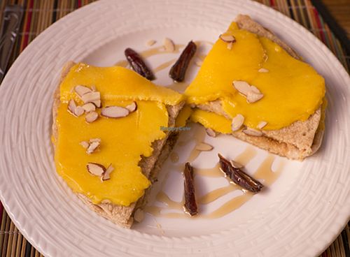 Breakfast item: oat pancakes layered with fresh mango, with dates and slivered almonds. at Kalenda in Santo Domingo