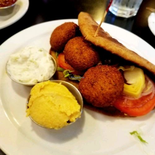 Falafel wrap with hummus and vegan tzatziki sauce on the side.   at The Elusive Cow in Bellevue