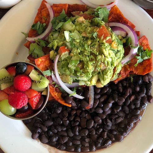 Red Chilaquiles Platter topped with Guacamole at Un Solo Sol in Los Angeles