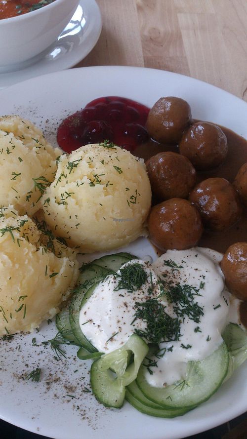 Potato puree with dill, cranberry sauce, cucumber salad and Polish version of meat balls - 'klopsiki'. The dish is called KLOPSIKI. at Lokal Vegan Bistro in Warsaw