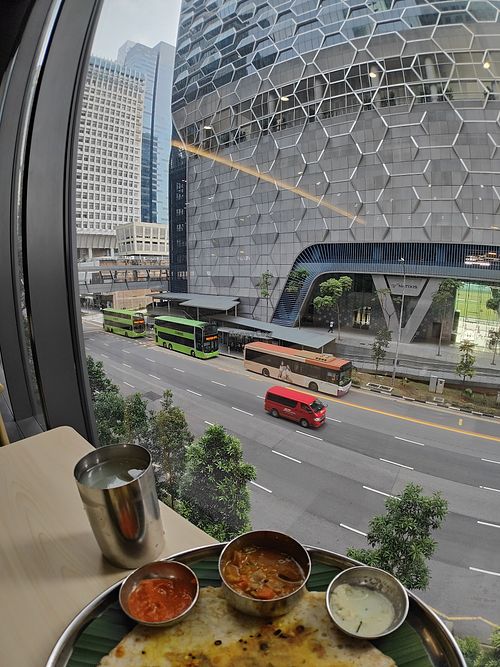 Masala oottappam and view of bus stop and UIC building at Annalakshmi Restaurant in Central Singapore