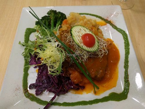 Homemade seitan steak with tomato and onion at Yerbabuena - Bordadores in Madrid