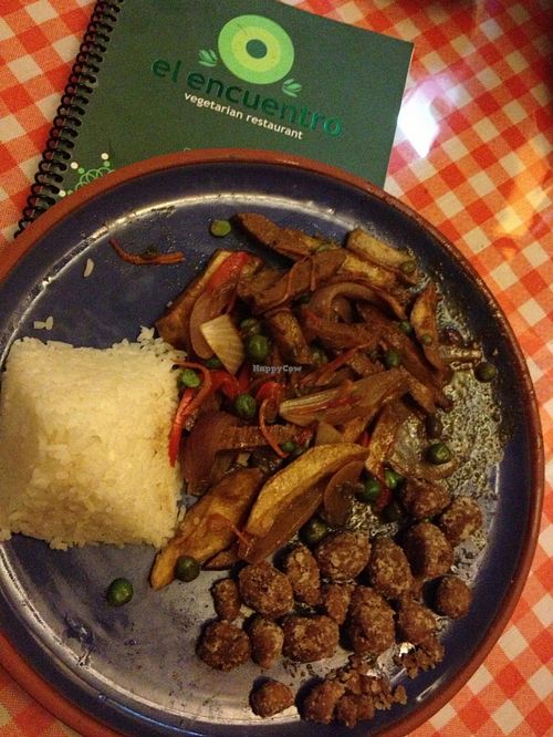Lomo saltado, Peru's national dish: seitan-like stir-fried strips with onion and mushroom in a hearty brown gravy, flavored with a touch of soy sauce. Also pictured: vegan 'chicharrones', crunchy bites that soak up the fresh pico de gallo. at El Encuentro - Choquechaca in Cusco