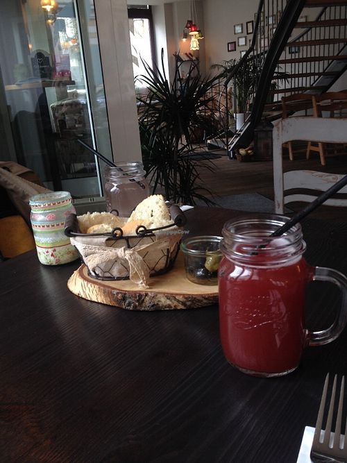 Our drinks, a really tasty strawberry Schorle, and complimentary bread and olives. at GreenSoul in Leipzig
