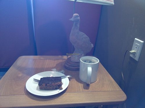 Vegan carrot cake with coffee and duckish table lamp. at Heaven on Earth Cafe in Vancouver