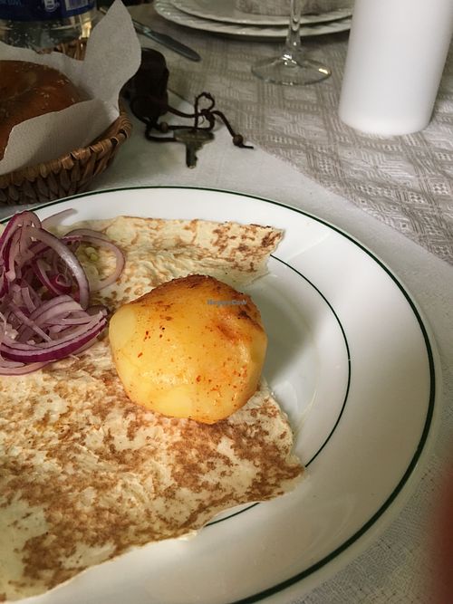 Grilled potatoes served on pita bread with raw onions  at Platan in Samarkand