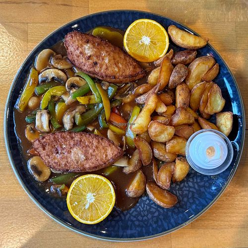 Chicken style schnitzel in brown sauce with potato  wedges at Ronja in Muelheim