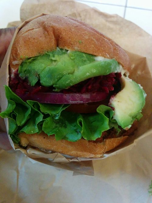 Avocado beetroot burger; crisp GMO free plant protein patty topped with avocado, shredded beets, red leaf lettuce, sliced red onion, creamy vegan aioli, whole wheat bun at VeganBurg in San Francisco