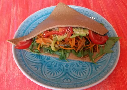 Raw Wrap made from flax seeds with sesame, arugula, zucchini spaghetti, carrot spaghetti, avocado, almond cream, and pesto at Delicious Vegan Bistro in Vienna