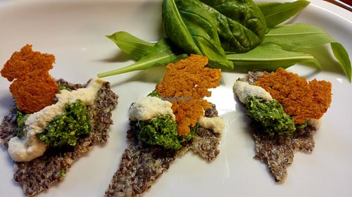 Raw crackers with spinach pesto, cashew cheese sauce and dehydrated hummus. at Ficus in Oslo