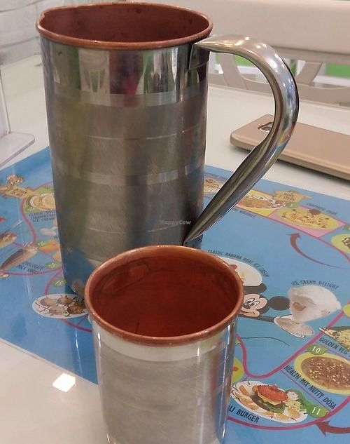 Cumin infused water served in copper jugs and cups.  at Greenleaf Cafe in Central Singapore