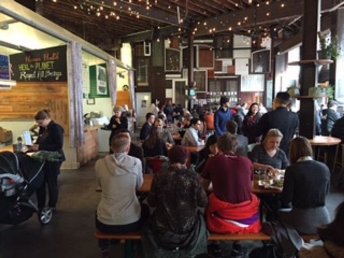 View of the Hall with seating shared by about 6 food/drink vendors at Kit Fox at the Hall in San Francisco
